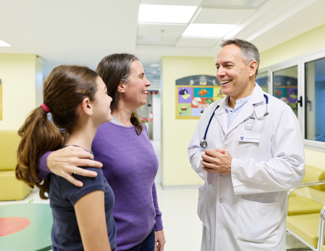 Personal administrativo del IADT entregando documentación a una paciente en el área de recepción
