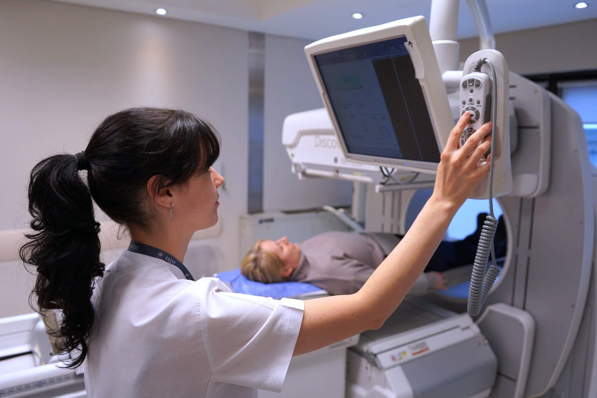 Técnica del Servicio de Medicina Nuclear del IADT preparando a una paciente para un estudio SPECT/CT