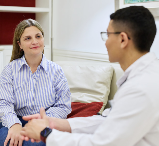 Profesional de la salud conversa con una paciente internacional.