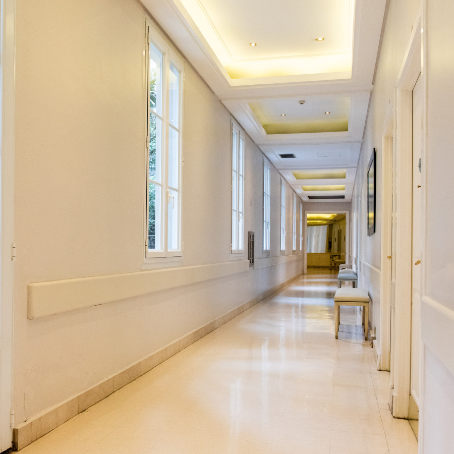 Pasillo de internación del IADT con amplios ventanales, iluminación natural y espacios diseñados para la comodidad de los pacientes.